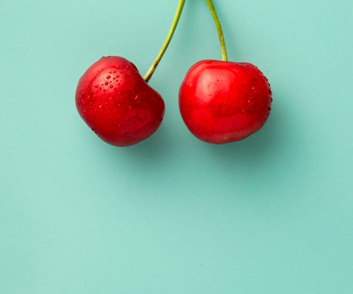 Cherry on green background